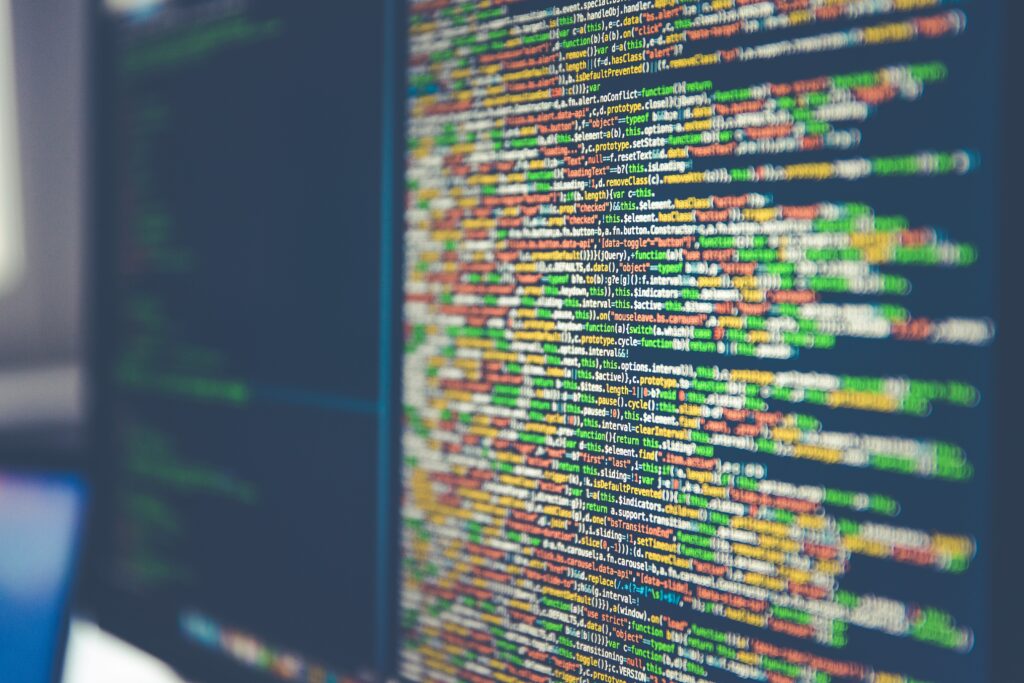Dense, tangled lines of source code filling a monitor at a sharp angle